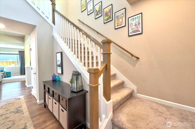 staircase with baseboards and wood finished floors
