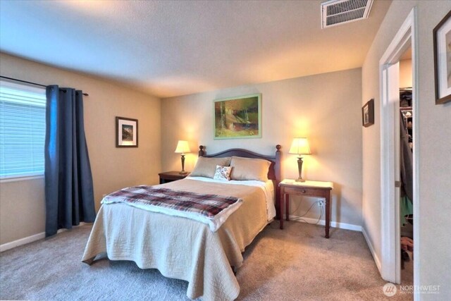 carpeted bedroom with baseboards and visible vents