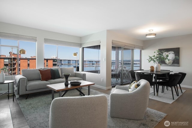 living room with a water view and baseboards