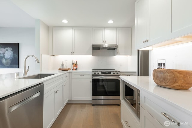 kitchen featuring a sink, white cabinetry, appliances with stainless steel finishes, and under cabinet range hood