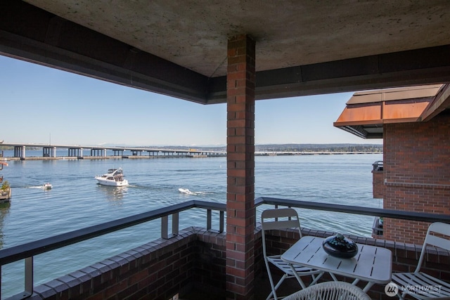 dock area with a water view and a balcony