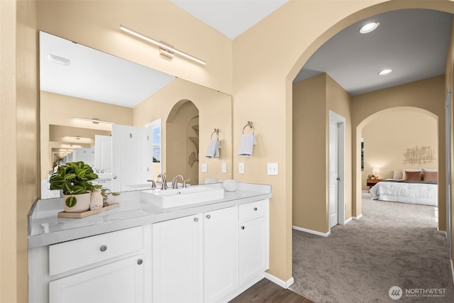 bathroom with connected bathroom, baseboards, and vanity