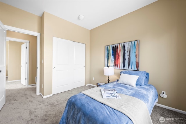 carpeted bedroom with baseboards and a closet