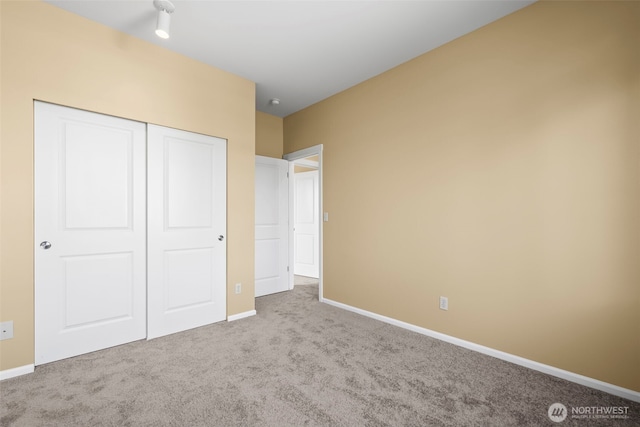 unfurnished bedroom with carpet flooring, baseboards, and a closet
