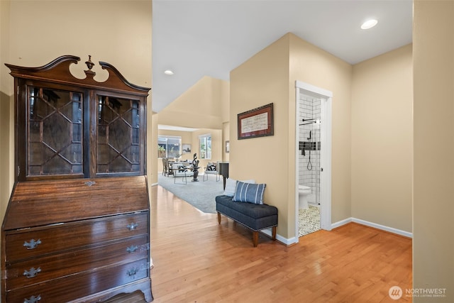 hallway featuring baseboards, recessed lighting, and wood finished floors