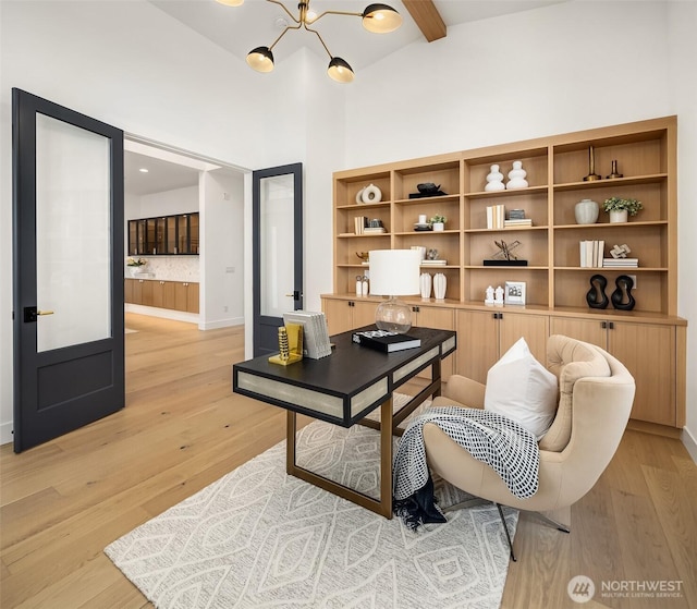 office featuring beam ceiling, baseboards, a high ceiling, a chandelier, and light wood finished floors