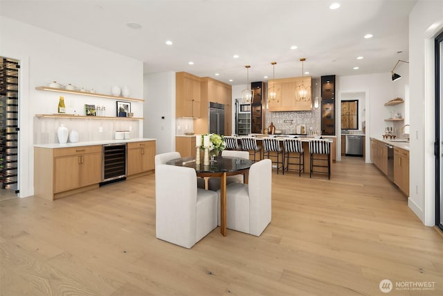 dining area with beverage cooler, recessed lighting, a dry bar, and light wood-type flooring