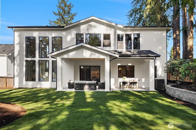rear view of property featuring an outdoor living space, a patio area, a yard, and cooling unit