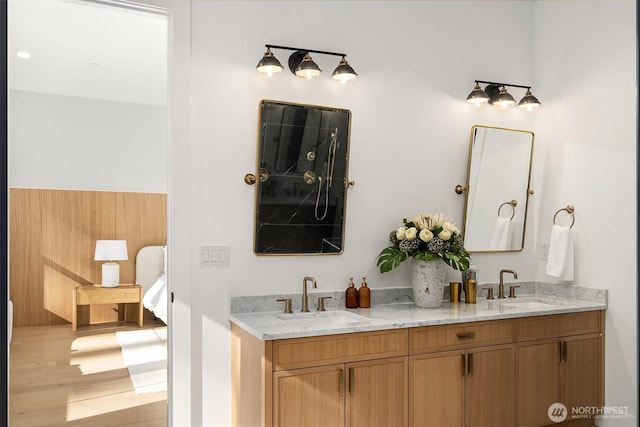 bathroom featuring a sink, double vanity, and wood finished floors