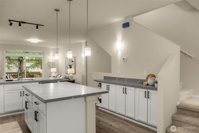 kitchen featuring a center island, a sink, white cabinetry, and dark wood-style floors