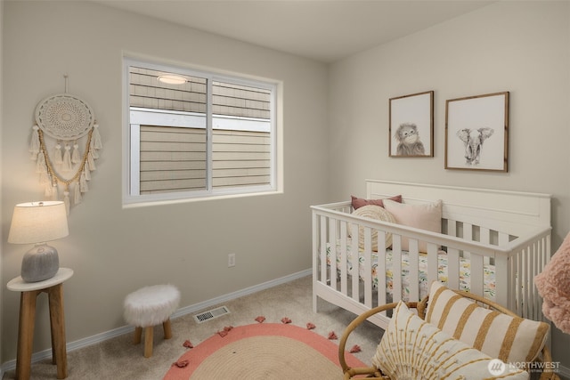 carpeted bedroom featuring baseboards, visible vents, and a crib