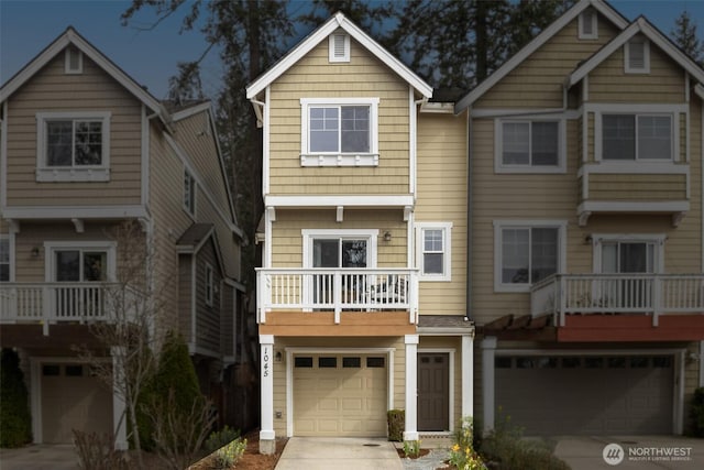 view of front of property featuring an attached garage, driveway, and a balcony