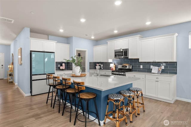 12011 SE 299th Pl, Auburn, WA 98092 - kitchen featuring visible vents, a sink, a breakfast bar, and stainless steel appliances