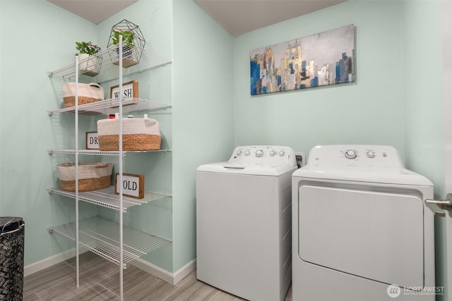 12011 SE 299th Pl, Auburn, WA 98092 - washroom with laundry area, baseboards, wood finished floors, and washing machine and clothes dryer