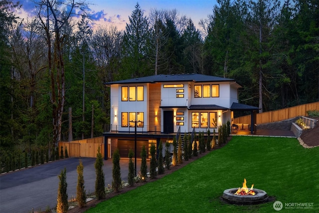 3230 290th Way NE, Redmond, WA 98053 - back of house at dusk featuring driveway, an attached garage, an outdoor fire pit, and stairway