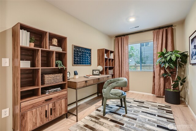 office area featuring baseboards, visible vents, and light wood finished floors