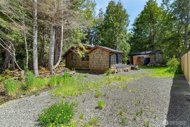 exterior space with fence, an outbuilding, and a shed