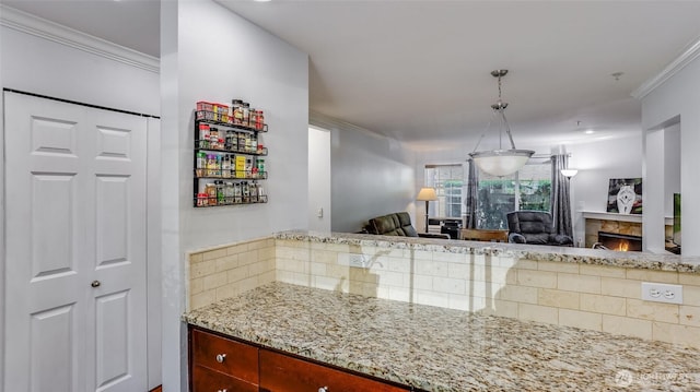 25025 SE Klahanie Blvd Unit L104, Sammamish, WA 98029 - kitchen featuring decorative backsplash, crown molding, light stone countertops, a warm lit fireplace, and open floor plan