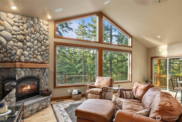 1570 Skull Springs Rd, Cle Elum, WA 98922 - living area featuring vaulted ceiling, a stone fireplace, wood finished floors, plenty of natural light, and recessed lighting