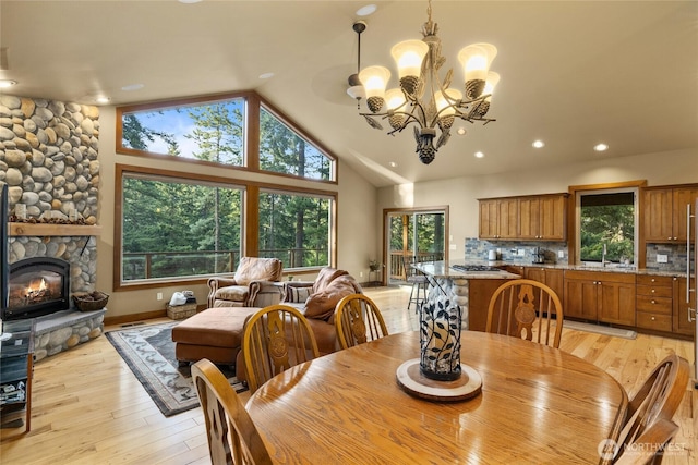 1570 Skull Springs Rd, Cle Elum, WA 98922 - dining room with lofted ceiling, light wood finished floors, a chandelier, a stone fireplace, and recessed lighting