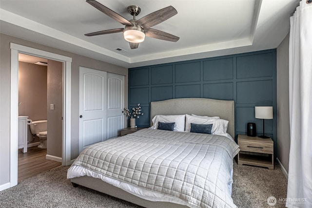 bedroom featuring baseboards, a tray ceiling, carpet flooring, and visible vents