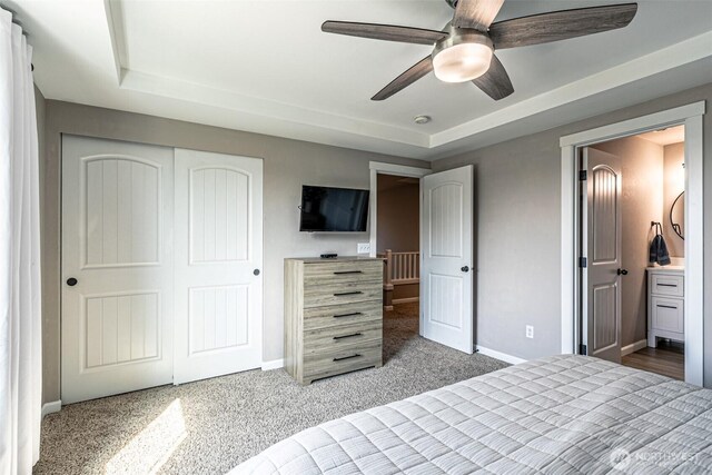 unfurnished bedroom with baseboards, a raised ceiling, and a closet