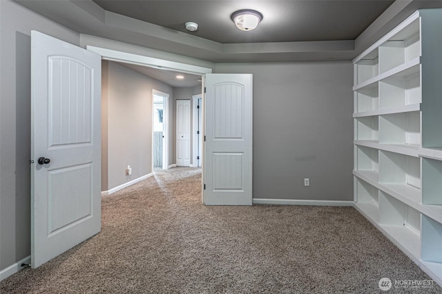 unfurnished room with carpet floors and baseboards