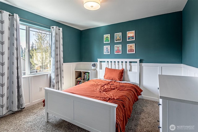 carpeted bedroom with a wainscoted wall