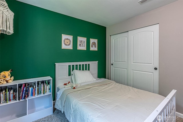 carpeted bedroom with baseboards and a closet