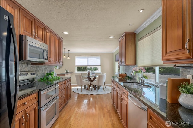 1319 Madrona Way NW, Gig Harbor, WA 98332 - kitchen with brown cabinets, a sink, stainless steel appliances, light wood-type flooring, and ornamental molding
