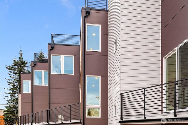 view of side of home with a balcony and stucco siding