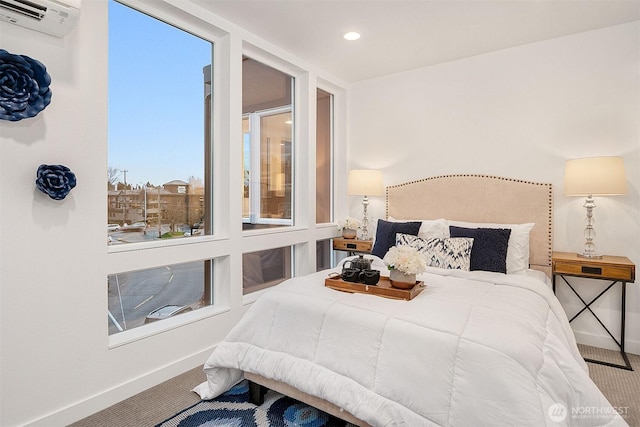 carpeted bedroom featuring baseboards, a wall mounted air conditioner, and recessed lighting