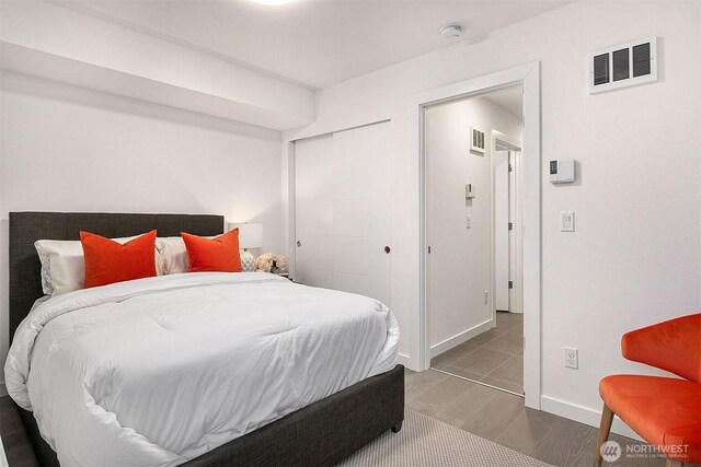 bedroom featuring wood finished floors, a closet, and baseboards