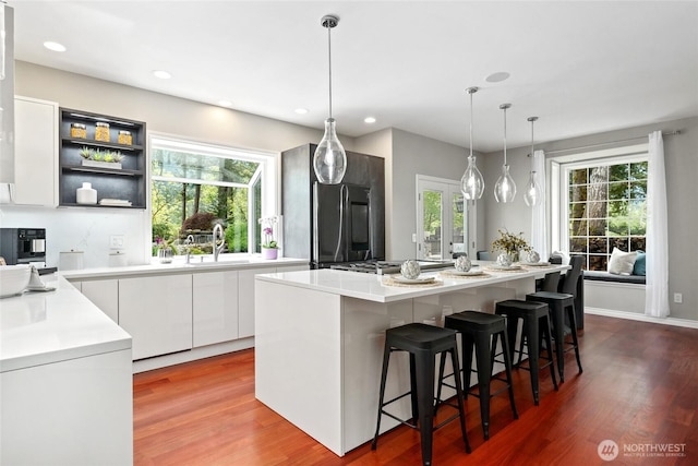 46707 SE 156th Pl, North Bend, WA 98045 - kitchen featuring fridge, white cabinetry, stainless steel gas stovetop, wood finished floors, and a kitchen island