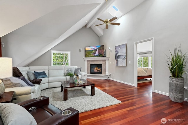 46707 SE 156th Pl, North Bend, WA 98045 - living area featuring wood finished floors, healthy amount of natural light, a tiled fireplace, a ceiling fan, and beamed ceiling