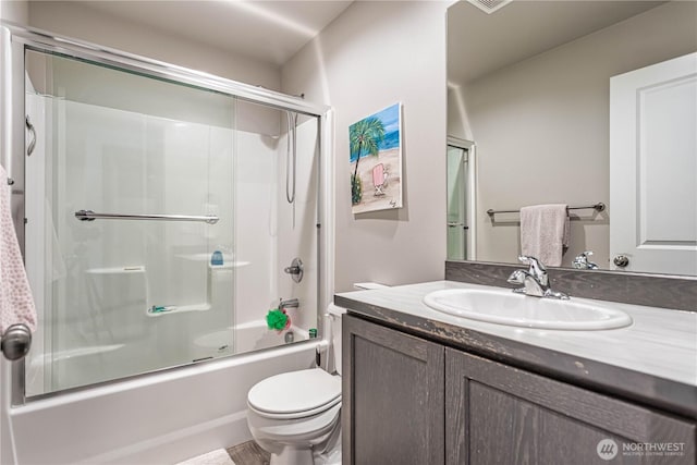 bathroom featuring vanity, enclosed tub / shower combo, and toilet