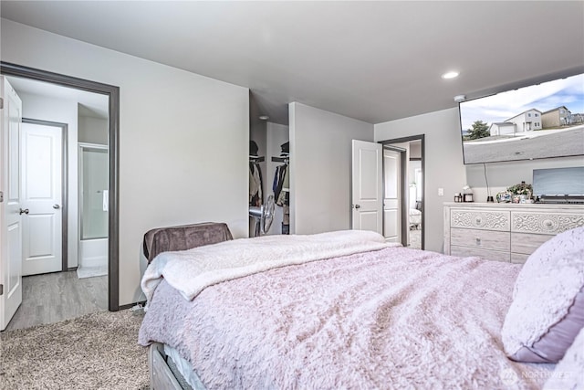 bedroom with ensuite bathroom and recessed lighting