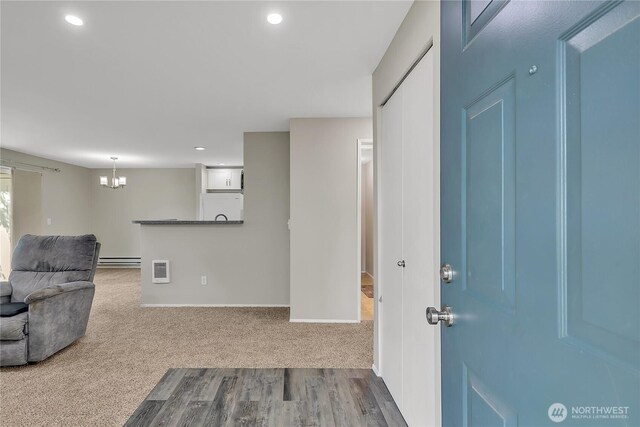 interior space with recessed lighting, a notable chandelier, and a baseboard heating unit