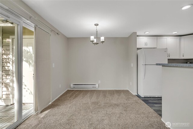 kitchen with a baseboard radiator, freestanding refrigerator, white cabinets, a chandelier, and recessed lighting