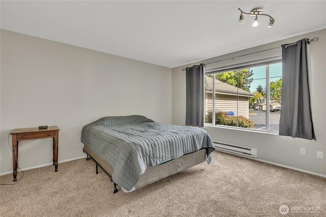 carpeted bedroom featuring baseboards and a baseboard heating unit
