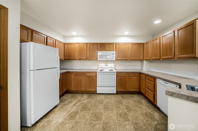 kitchen featuring light countertops, recessed lighting, brown cabinetry, and white appliances