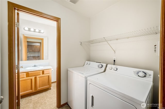 laundry room with washer and dryer, laundry area, baseboards, and a sink