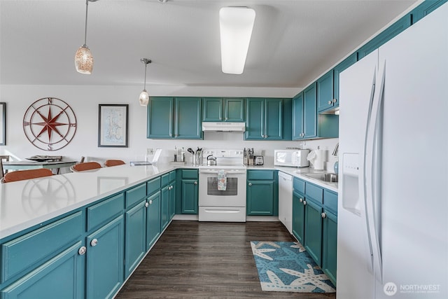 501 Shoreview Dr S Unit 204, Long Beach, WA 98631 - kitchen featuring white appliances, dark wood-type flooring, under cabinet range hood, light countertops, and hanging light fixtures