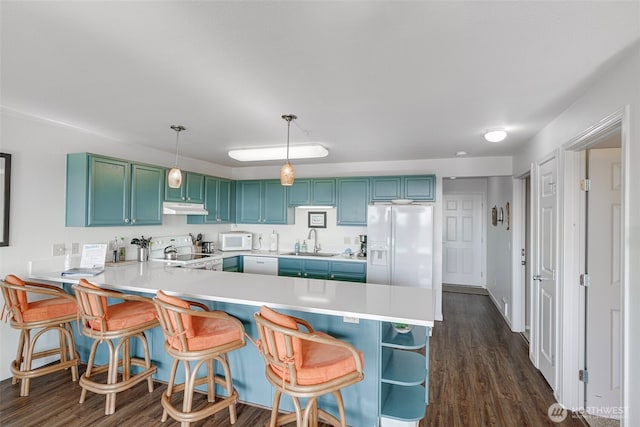 501 Shoreview Dr S Unit 204, Long Beach, WA 98631 - kitchen with under cabinet range hood, white appliances, a sink, a peninsula, and light countertops
