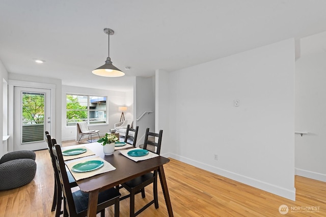 dining area featuring baseboards and light wood finished floors