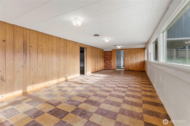 spare room featuring wood walls and light floors