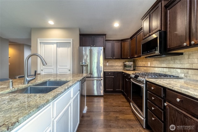 301 NE Danner Ln, College Place, WA 99324 - kitchen featuring dark brown cabinetry, dark wood finished floors, a sink, light stone counters, and stainless steel appliances