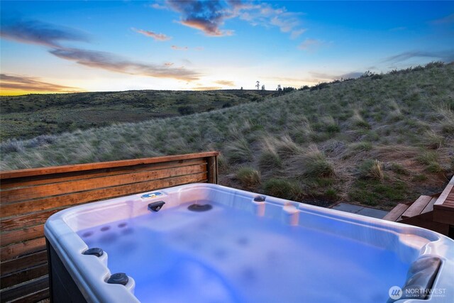 exterior space with a hot tub and a mountain view