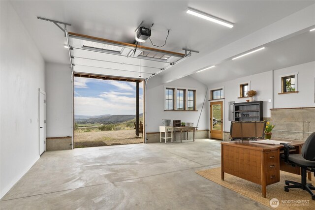 office featuring a garage, a mountain view, and concrete flooring