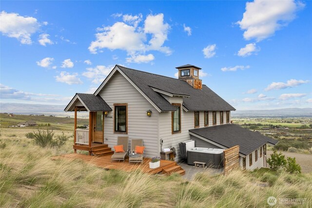 view of front of property with central AC unit and a shingled roof